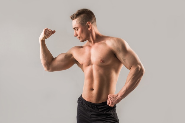 handsome man with muscles on gray background