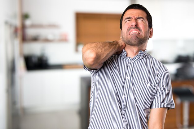 Handsome man with neck pain inside house