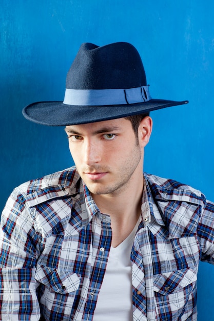 Foto bell'uomo con camicia a quadri e cappello da cowboy