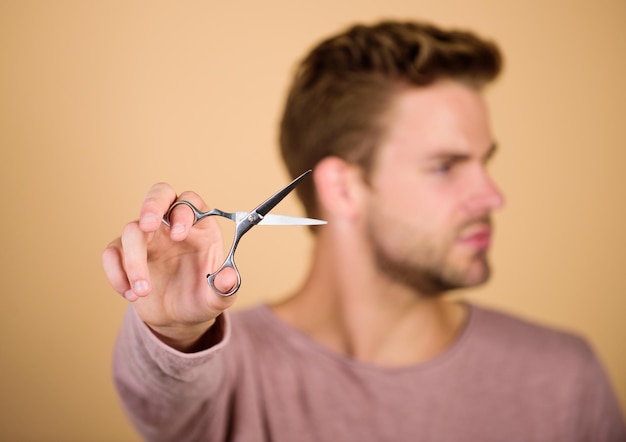 Handsome man with scissors Barbershop concept getting hairstyle Barber self care barber work Hair care equipment male grooming styling beard hair scissors selective focus hair cut tool