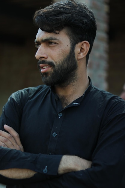 Handsome man with short bristles in a village in a beveled field