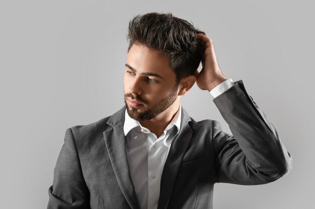 Handsome man with stylish hairdo on grey