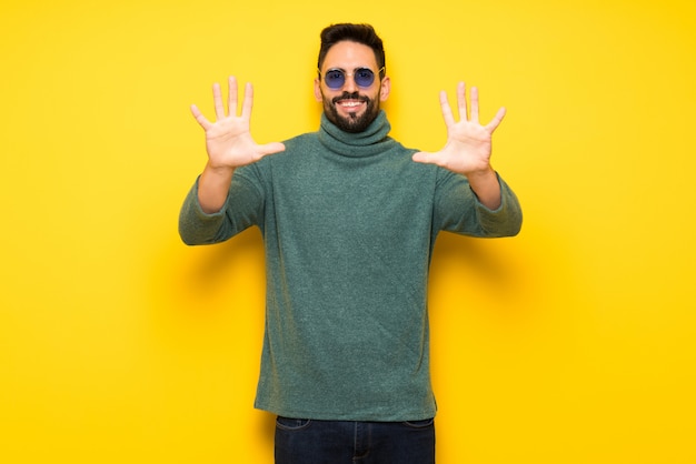 Handsome man with sunglasses counting ten with fingers