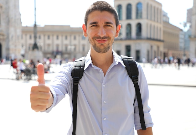 Handsome man with thumbs up in city street