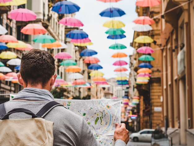 Handsome man with a tourist map on a cloudy day