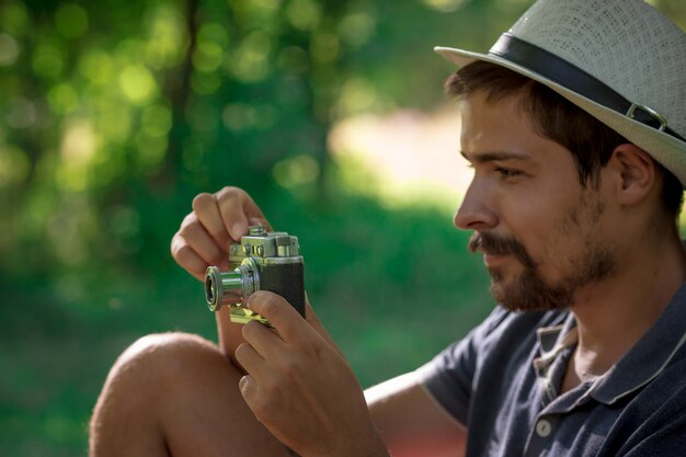 Handsome man with vintage camera in the forest