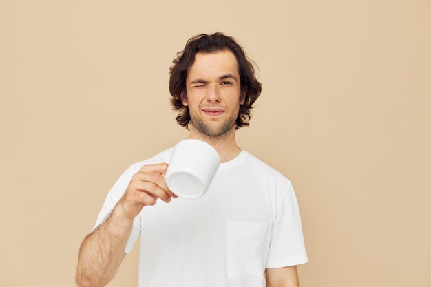 Handsome man with a white mug in his hands emotions posing isolated background