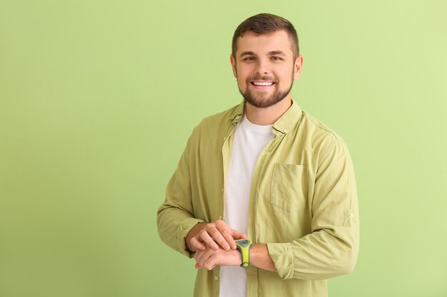 Handsome man with wristwatch on green