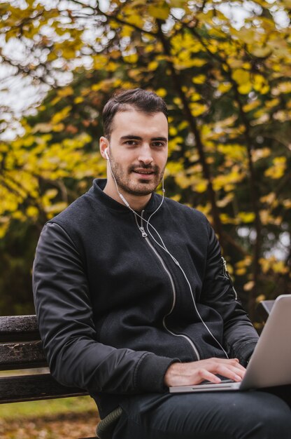 Handsome man working on his laptop outside