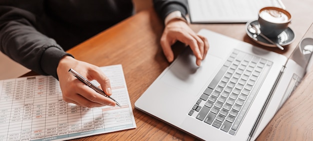 Uomo bello che lavora al computer portatile sul posto di lavoro