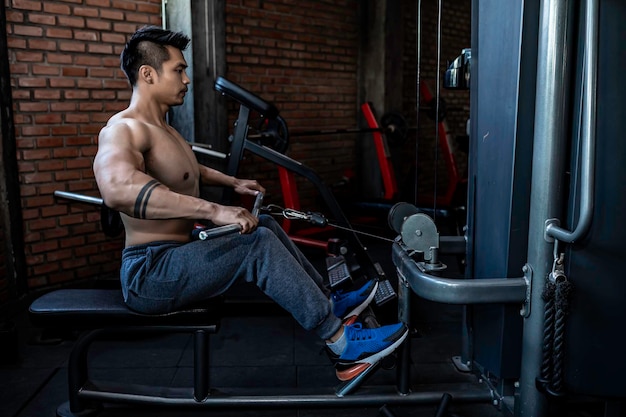 Handsome man working out in the gym Asian man doing weightlifting to compete in sportsPull up barbell for back training muscle