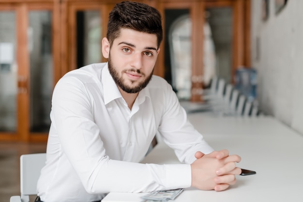 Handsome man at workplace with phone