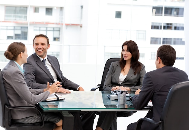 Handsome manager laughing during a meeting with his team