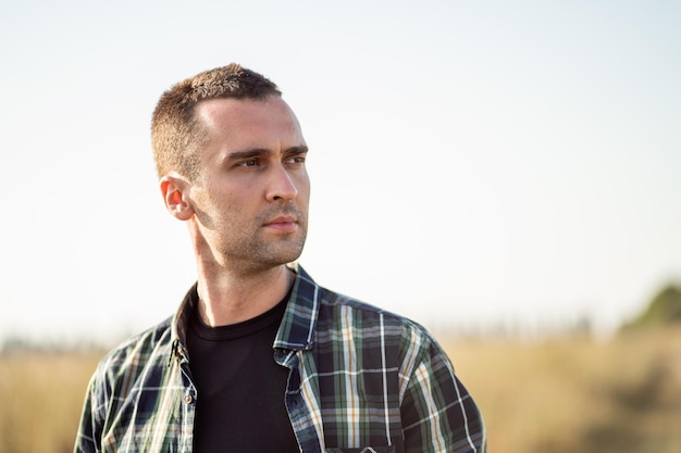 Handsome manly man with short bristles in a checkered shirt