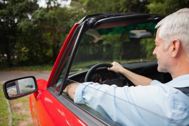 Uomo maturo bello che guida cabriolet