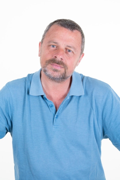 Handsome mature man posing in blue shirt on white studio background