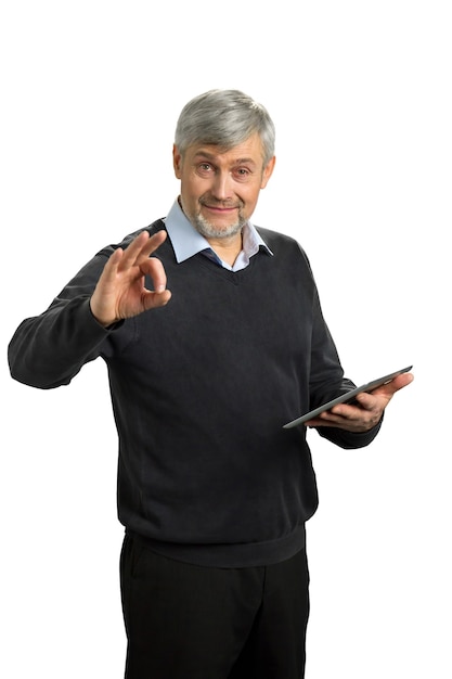 Handsome mature man showing Ok sign. Elderly man with digital tablet showing gesture ok on white.