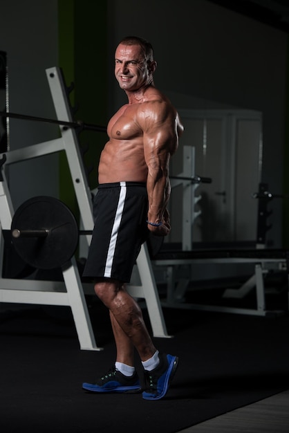 Handsome Mature Man Standing Strong In The Gym And Flexing Muscles  Muscular Athletic Bodybuilder Fitness Male Posing After Exercises