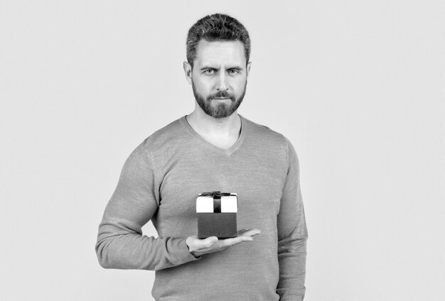 Handsome mature man with beard holding present box valentines day