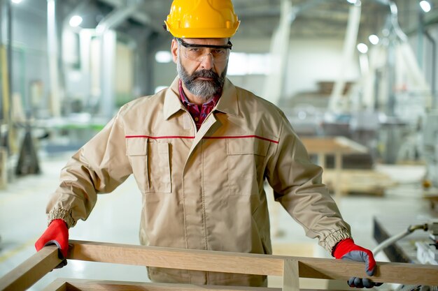 Handsome mature man working in the  modern furniture factory