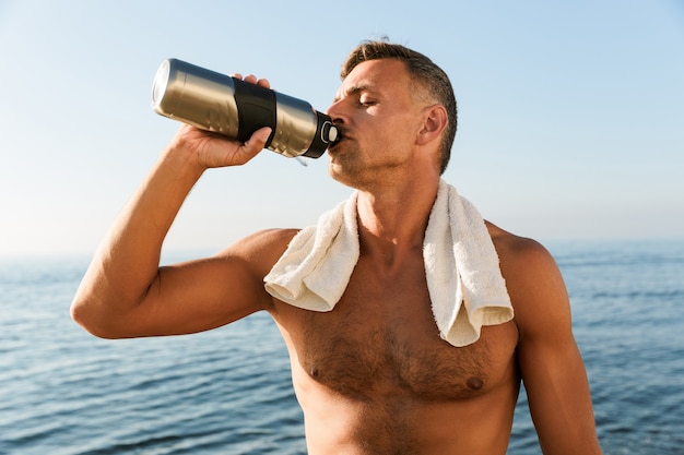 Handsome mature sportsman with towel