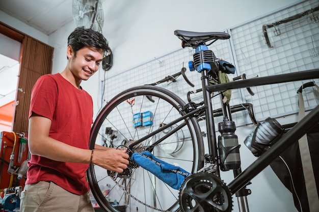 Foto un bel meccanico che lavora stringere l'asse della bicicletta con una chiave inglese