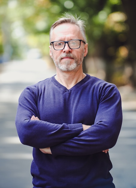 Photo handsome middle aged man with gray hair in an outdoor setting