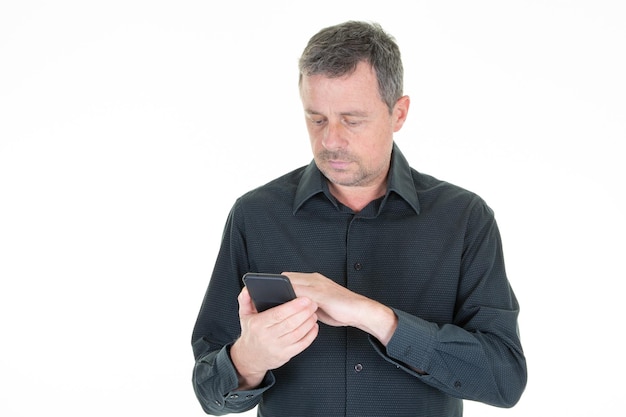 Handsome middle aged man writing sms text message on his cell phone screen