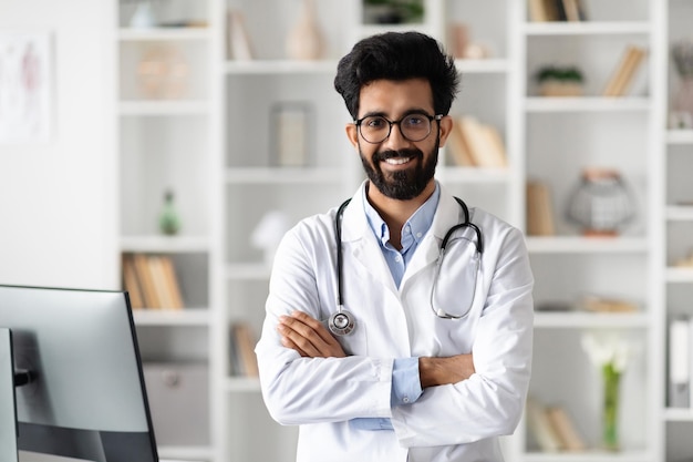 Handsome middle eastern family doctor posing at office at clinic