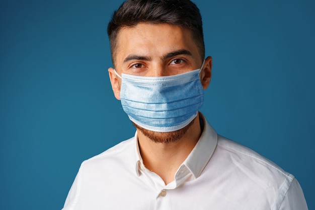 Handsome mixed-race man wearing medical face mask close up