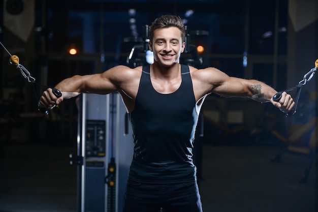 Allenamento di modello bello del giovane in palestra