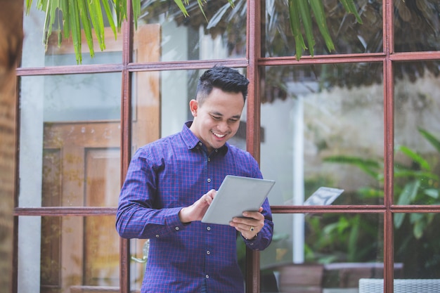 Handsome modern man smiling with tablet