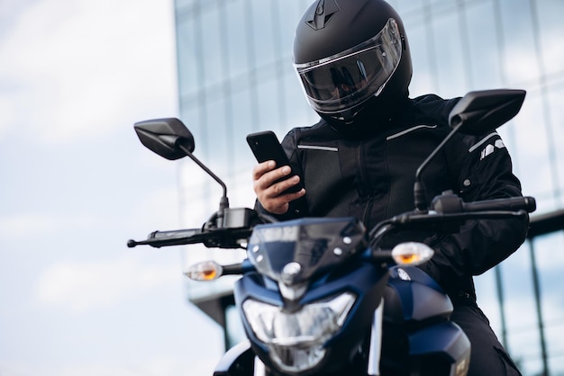 Handsome motorcyclist on his moto riding in the city