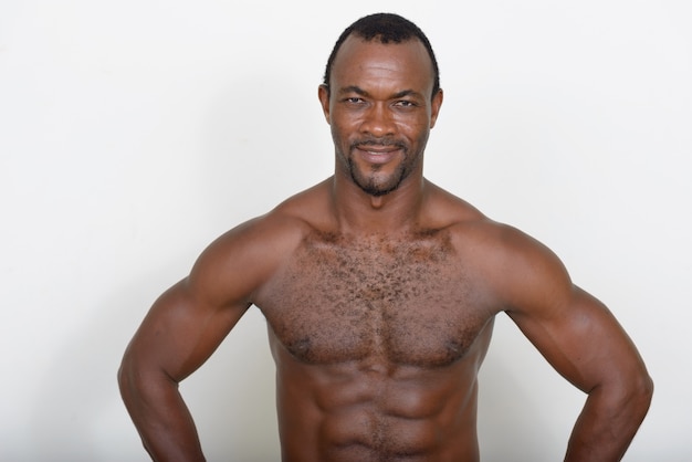 Photo handsome muscular bearded african man shirtless against white wall