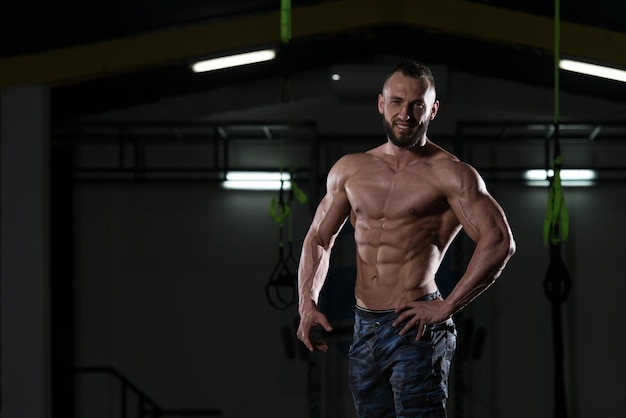 Handsome Muscular Man Flexing Muscles In Gym