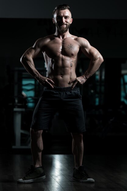 Handsome Muscular Man Flexing Muscles In Gym