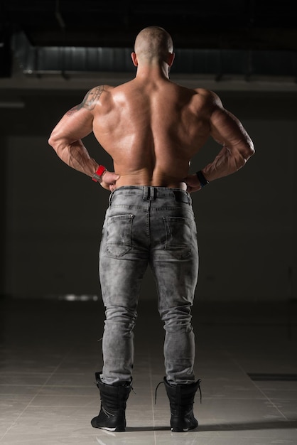 Фото Красивый мускулистый мужчина сгибает мышцы в тренажерном зале
