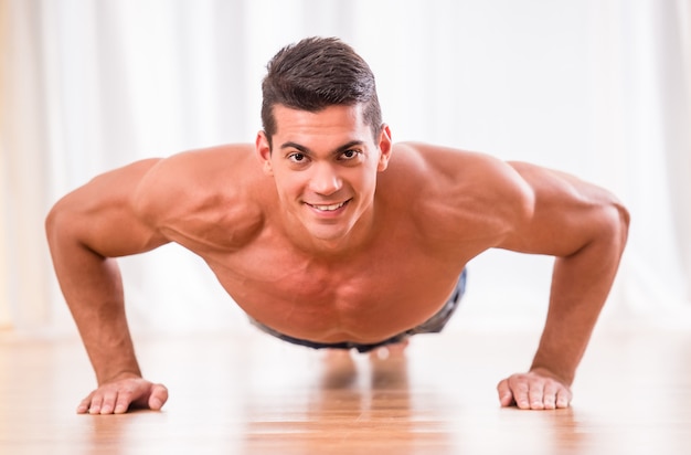 Handsome muscular man is doing push ups.