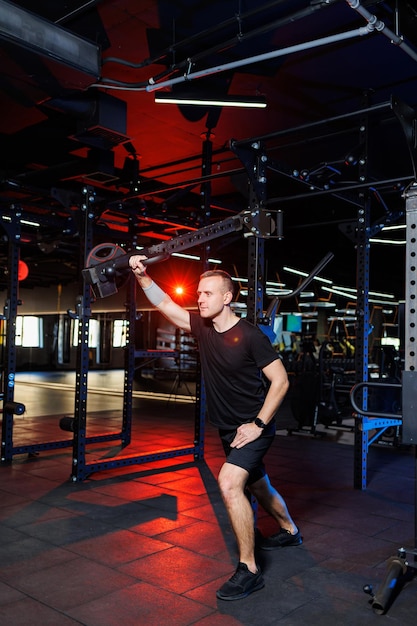 Handsome muscular man performing heavy exercises in the gym. Healthy lifestyle