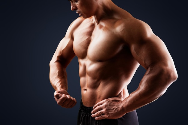 Handsome muscular man posing and flexing muscles