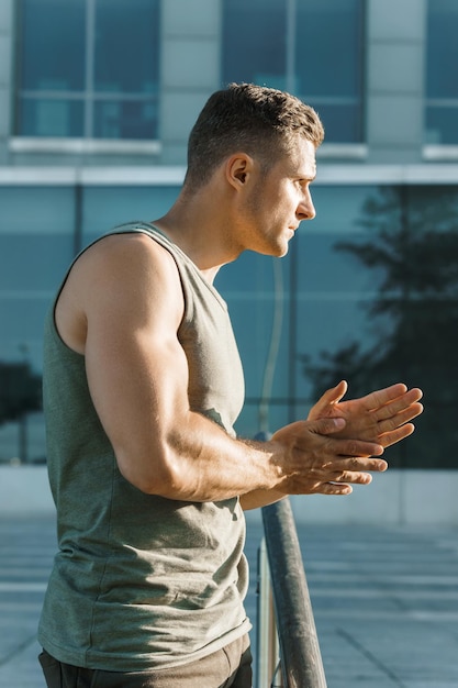 Handsome muscular man warming up before his outdoor fitness workout