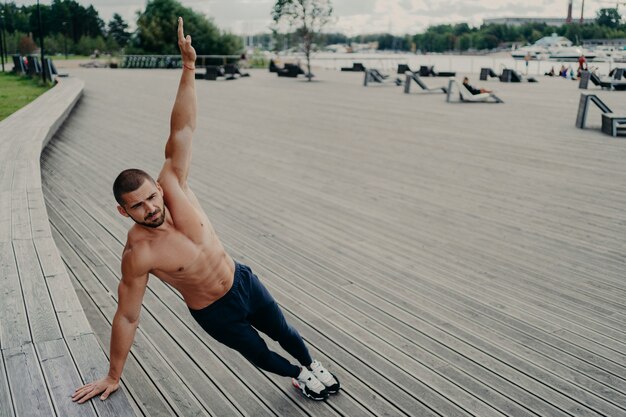 Handsome muscular man with naked torso outdoors doing fitness workout