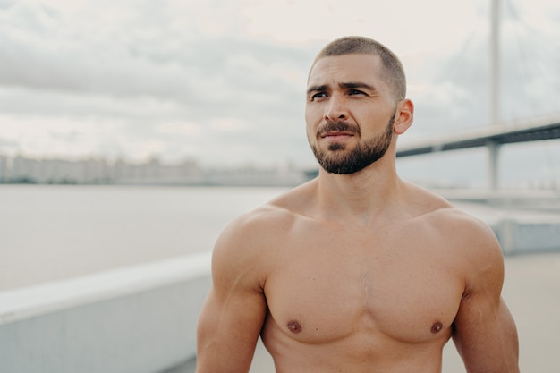 Handsome muscular man with naked torso outdoors doing fitness workout