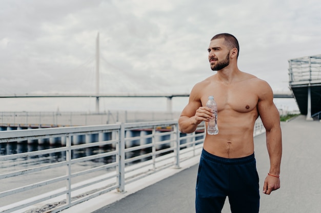 Handsome muscular man with naked torso outdoors doing fitness workout