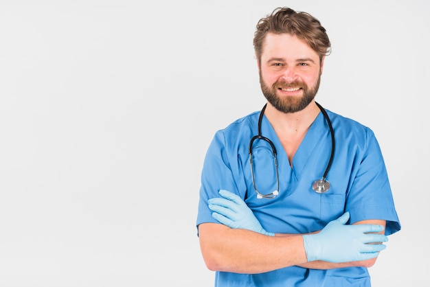 Handsome nurse male smiling and crossing hands