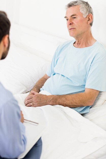 Photo handsome nurse visiting a mature man in bedroom