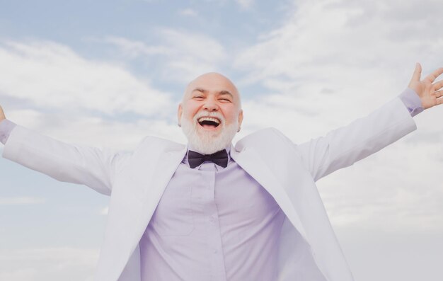 Handsome oldfashion winner senior old mature man vintage\
success male in white suit having fun