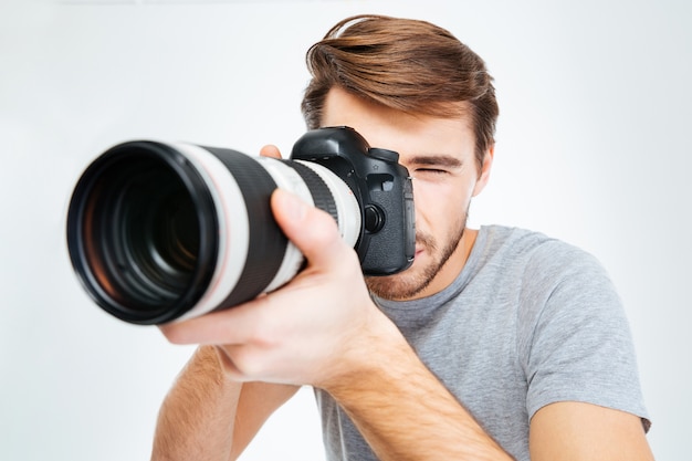 Handsome photographer making shot on photo camera