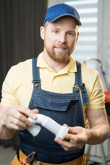 Handsome plumber holding pipe