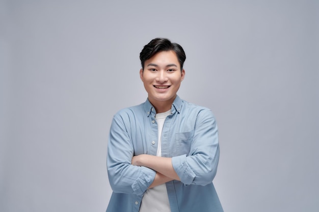 Красивый портрет молодого азиата, улыбающегося на белом фоне